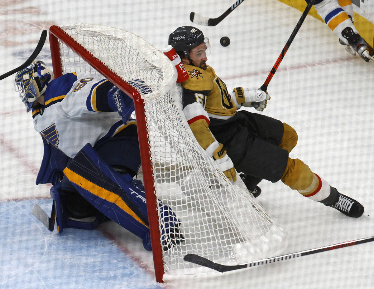 Golden Knights right wing Mark Stone (61) falls on St. Louis Blues goaltender Jordan Binnington ...