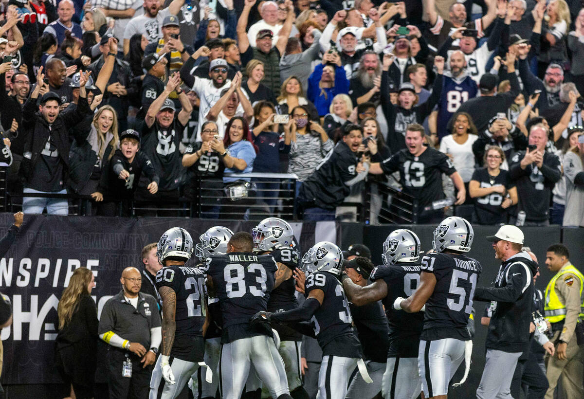 Raiders players celebrate a score by teammate defensive end Chandler Jones (55) to beat the New ...