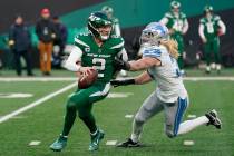 New York Jets quarterback Zach Wilson (2) scrambles under pressure from Detroit Lions linebacke ...