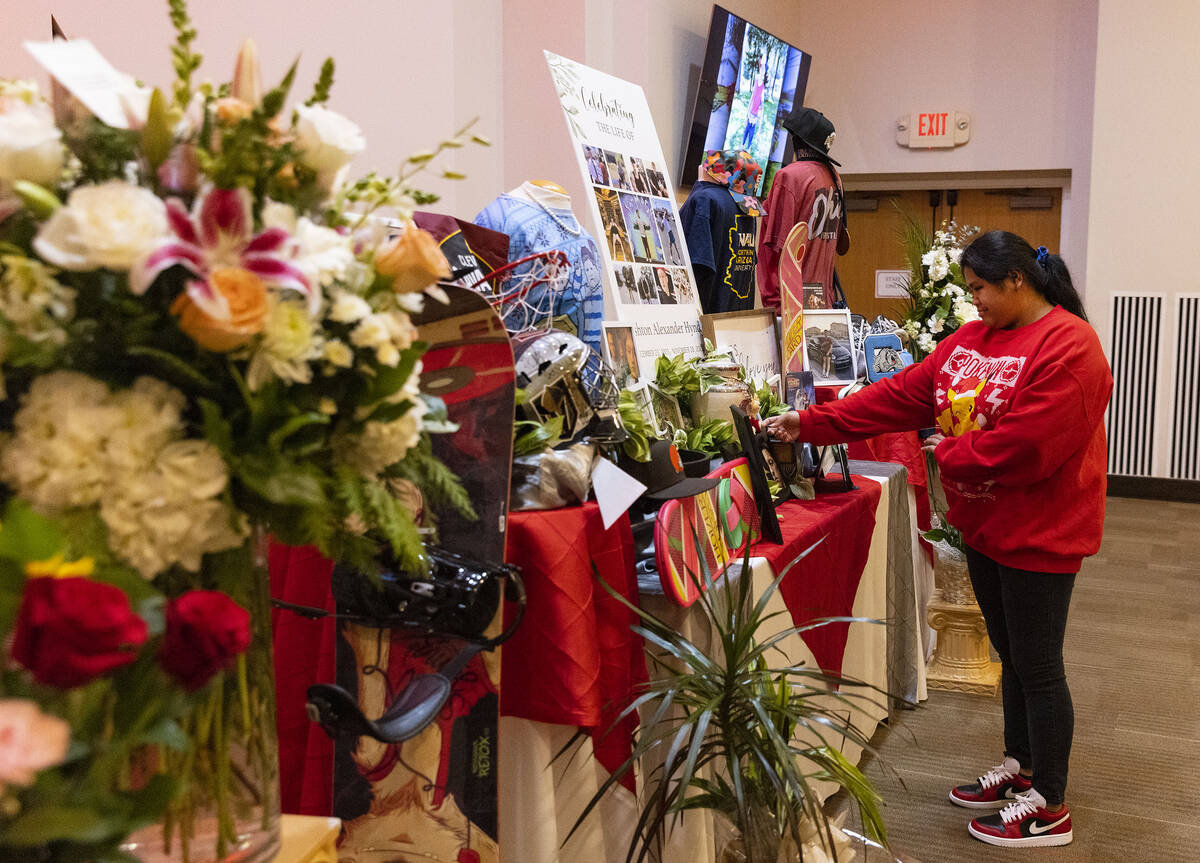 Shaira Cahilig, a friend of Ashton Hynd, touches a photograph of Hynd during a memorial service ...