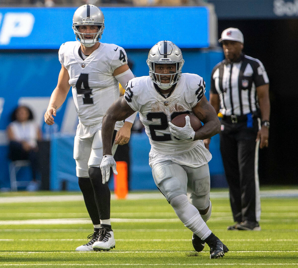 Raiders quarterback Derek Carr (4) looks on as running back Josh Jacobs (28) runs during the se ...