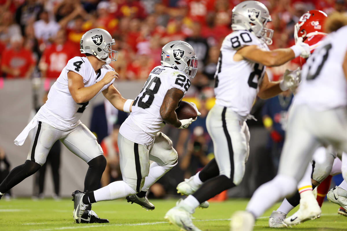 Raiders quarterback Derek Carr (4) hands off the ball to running back Josh Jacobs (28) for a ru ...