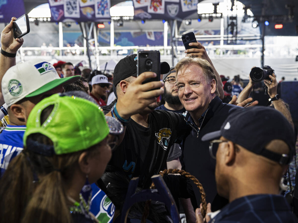 NFL commissioner Roger Goodell, right, socializes with fans during day three of the NFL draft o ...