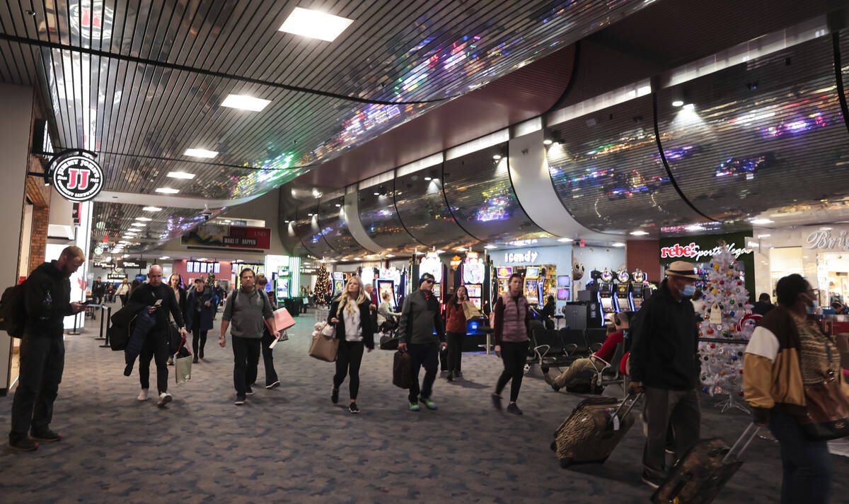 Travelers make their way through Harry Reid International Airport on Thursday, Dec. 22, 2022, i ...