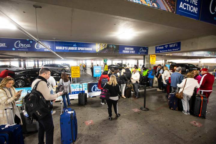 People wait in the ride share pickup area at Harry Reid International Airport on Thursday, Dec. ...