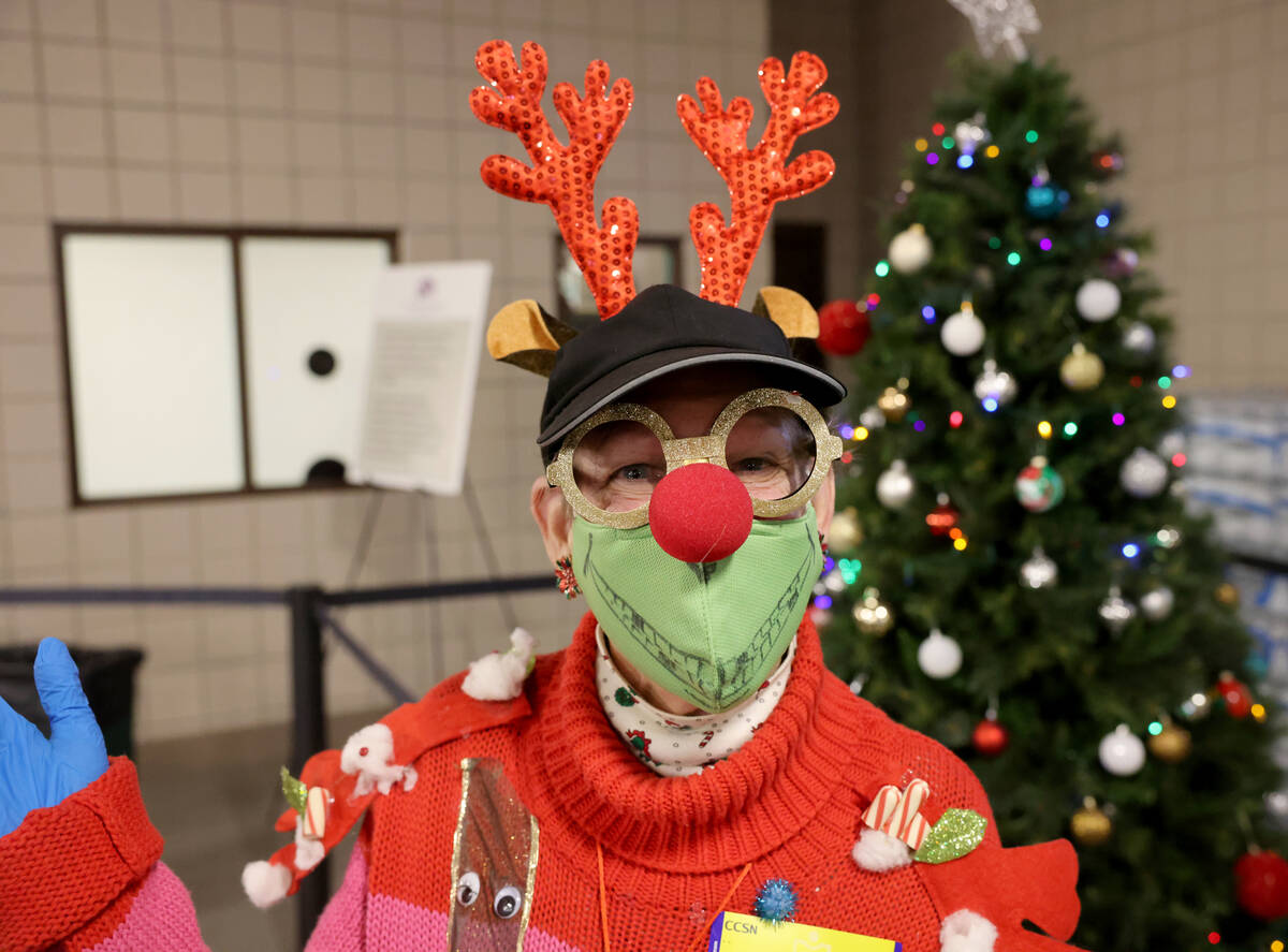 Volunteer interior Bette Kennedy hands out bottles of water during a Christmas meal at Catholic ...