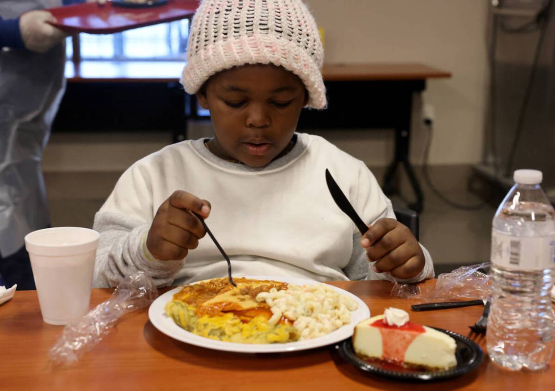 Jaylees Sims, 6, eats a Christmas meal at Catholic Charities of Southern Nevada in Las Vegas Su ...