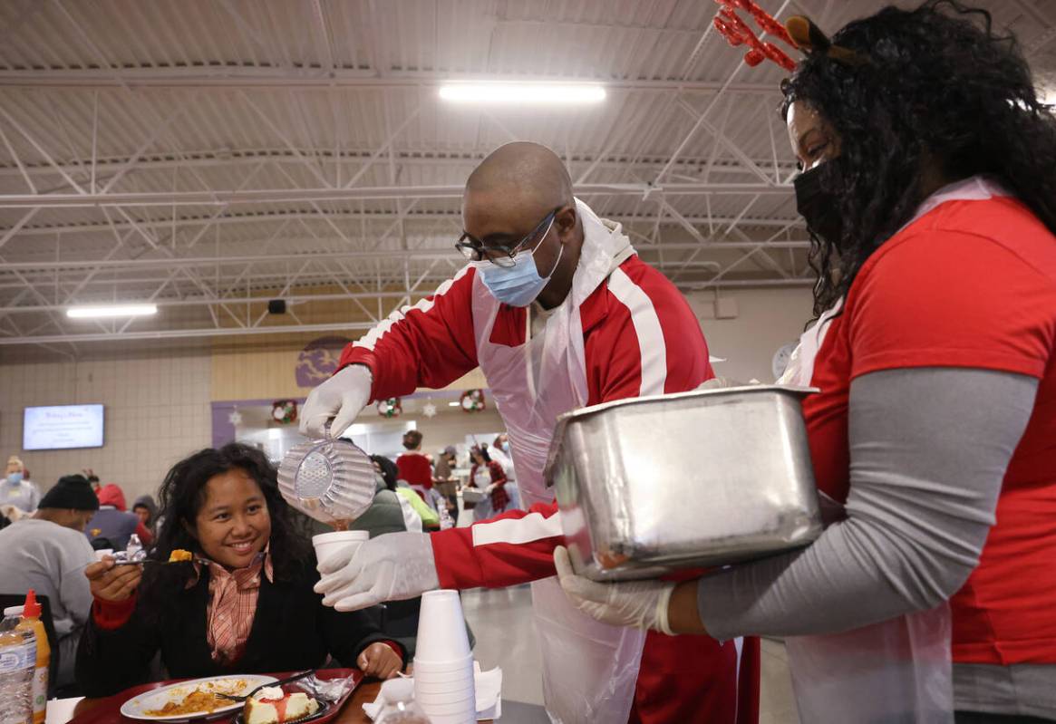 Volunteer Wiley Barnes pours hot chocolate as LaMadrid Marquez waits to pour marshmallows for D ...