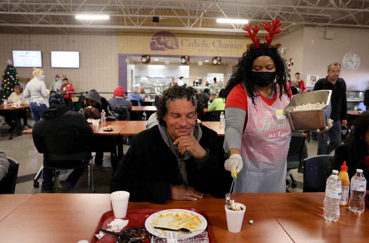 Volunteer LaMadrid Marquez pours marshmallows into hot chocolate for Mel Gibson, 52, during a C ...