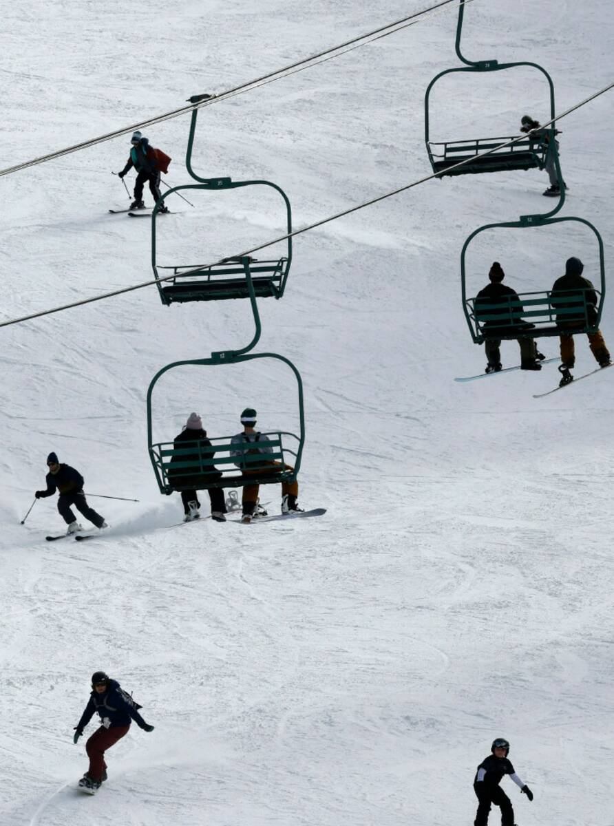 Skiers and snowboarders enjoy the slope as people ride chairlifts, Monday, Dec. 26, 2022, at th ...