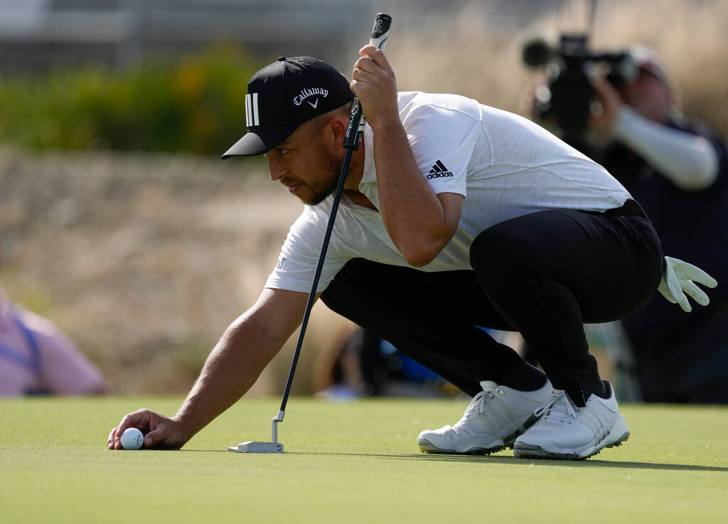 Xander Schauffele, of the United States, lines up a putt on the third green during the third ro ...
