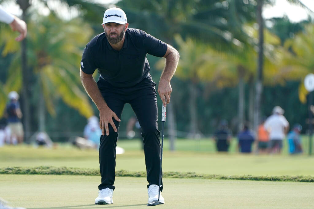 FILE - Dustin Johnson reacts after putting on the 17th green during the final round of the LIV ...