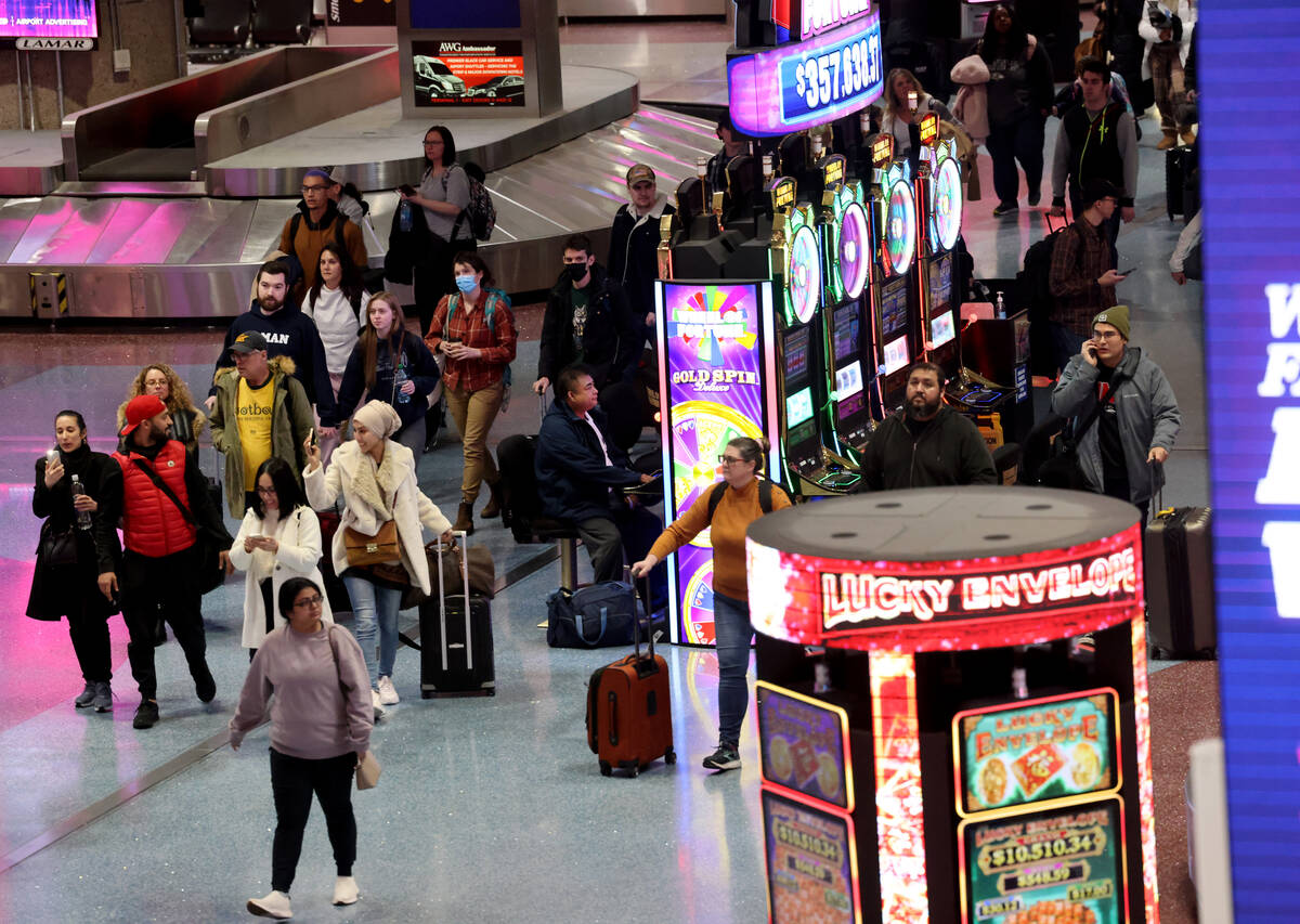 Passengers walk through the baggage claim area of Terminal 1 at Harry Reid International Airpor ...