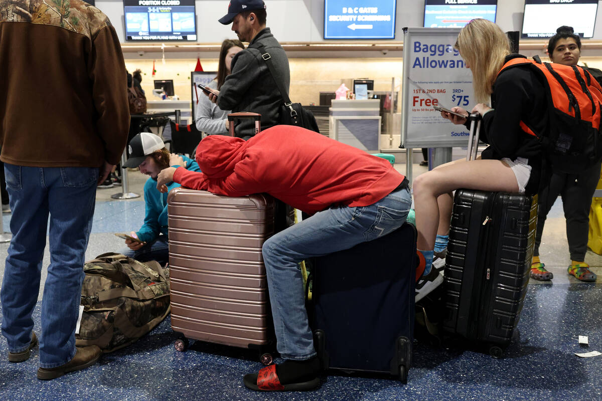 Hunter Murphy, 18, and his sister Presslie Murphy, 15, of Houston sit on luggage as they wait i ...