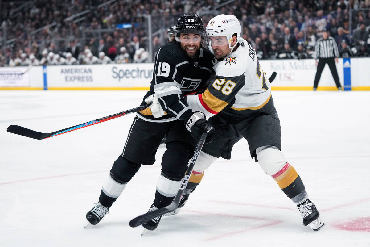 Los Angeles Kings' Alex Iafallo (19) is defended by Vegas Golden Knights' William Carrier (28) ...