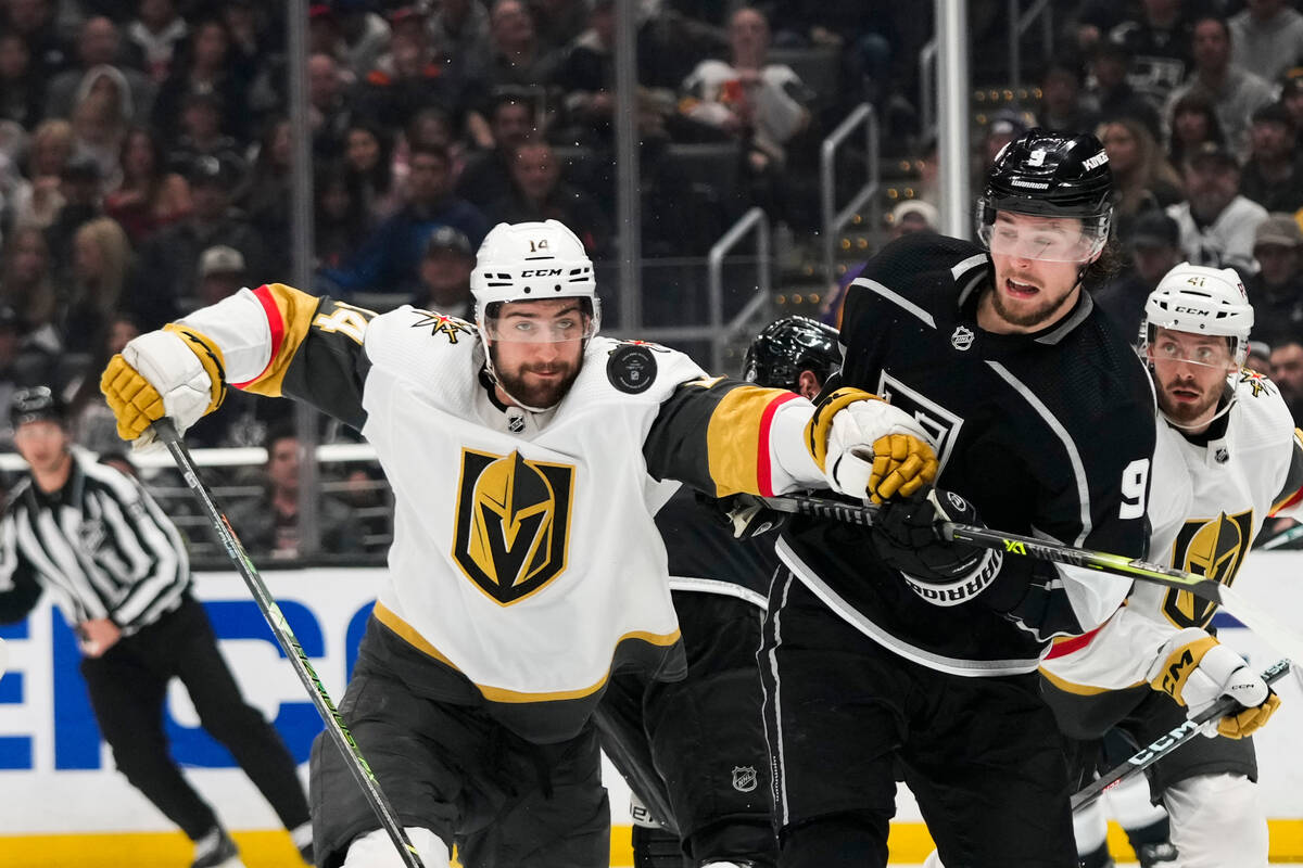 Vegas Golden Knights' Nicolas Hague (14) and Los Angeles Kings' Adrian Kempe (9) vie for the pu ...