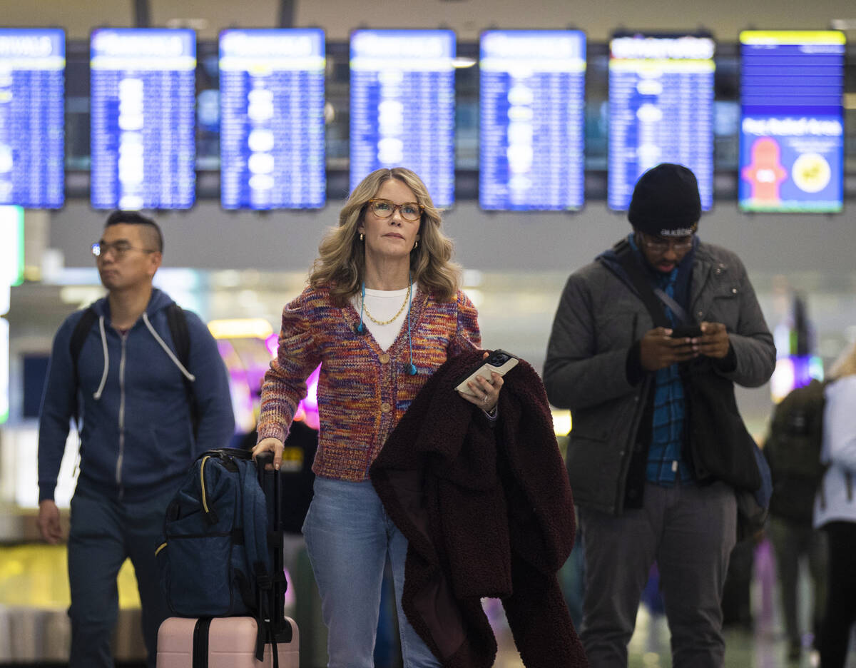 Travelers walk through terminal 1 at Harry Reid International Airport on Sunday, Nov. 27, 2022, ...