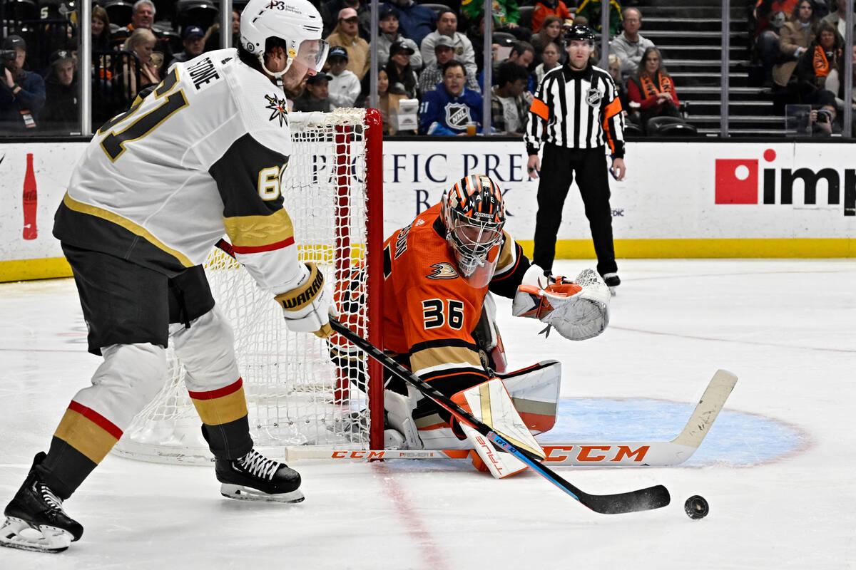 Vegas Golden Knights right wing Mark Stone, left, passes the puck in front of Anaheim Ducks goa ...