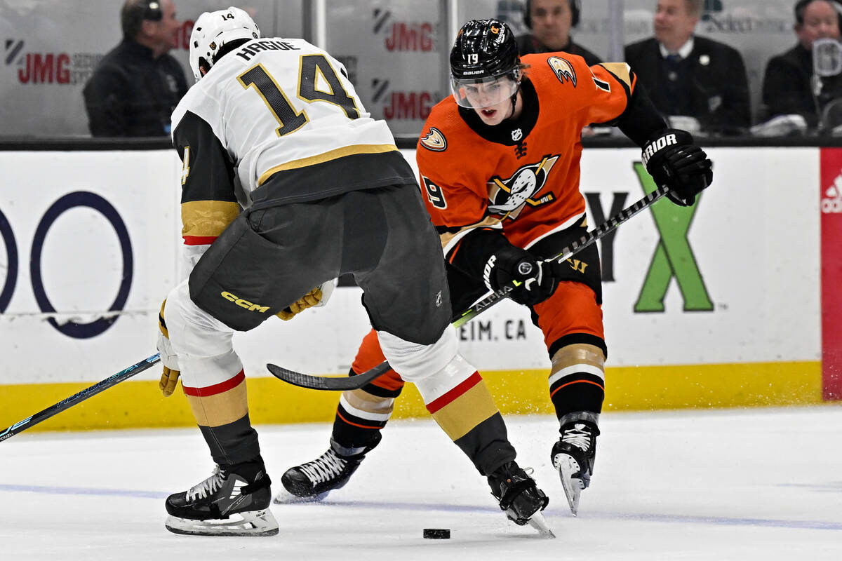 Anaheim Ducks right wing Troy Terry, right, passes the puck between the skates of Vegas Golden ...
