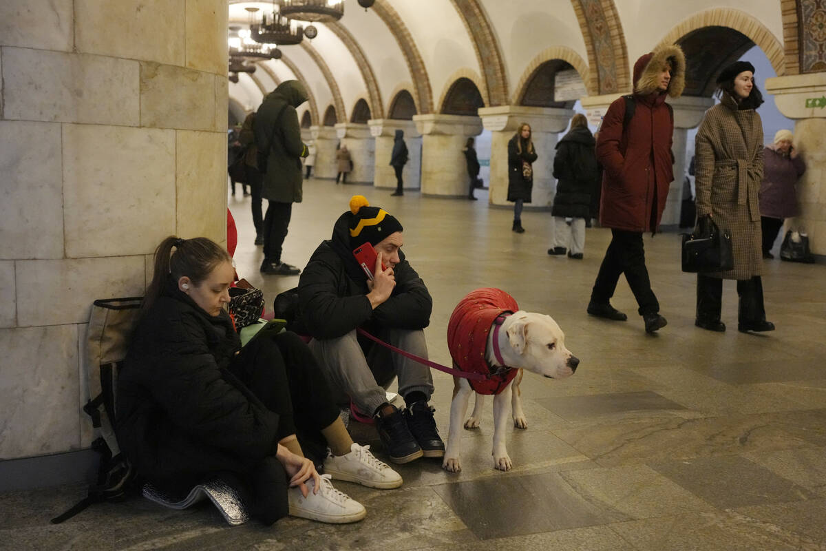 People rest in the subway station being used as a bomb shelter during a rocket attack in Kyiv, ...