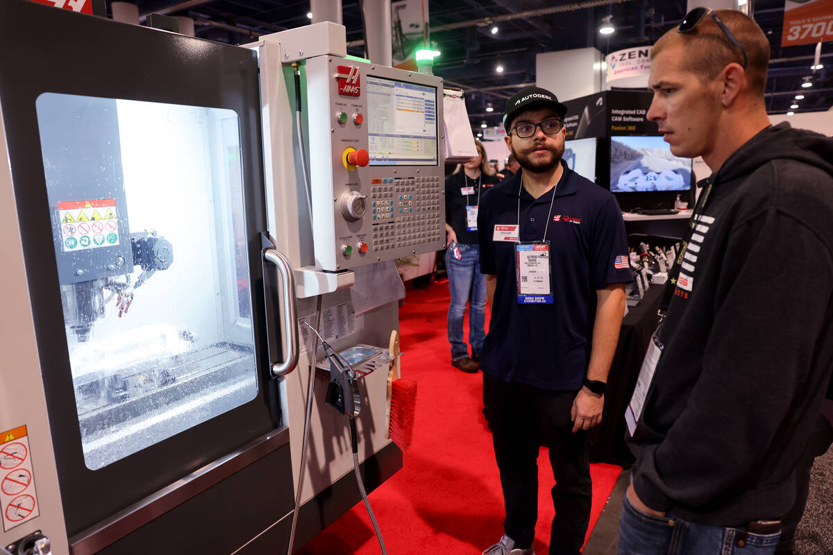 Alfredo Fierros of Haas Automation in Oxnard, Calif., left, shows a machine tool on Day 2 of th ...