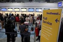 Passengers wait in line at the Southwest ticket counter in Terminal 1 at Harry Reid Internation ...