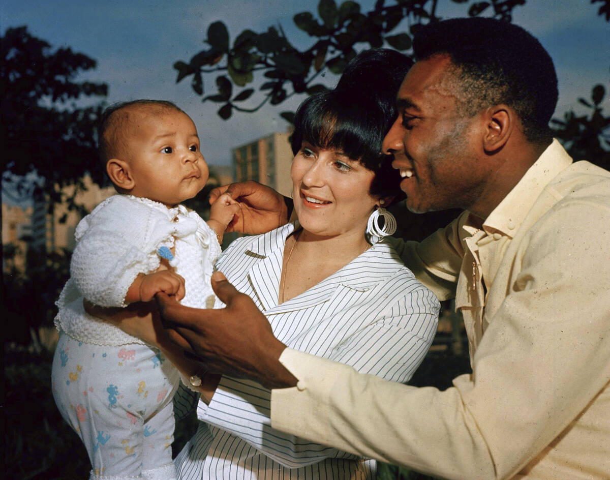Brazilian soccer star Pele and his wife Rosemeri pose for a photo with their daughter Kelly, in ...