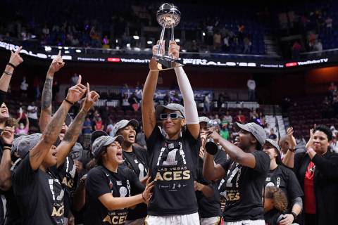Las Vegas Aces' A'ja Wilson holds up the championship trophy as she celebrates with her team th ...