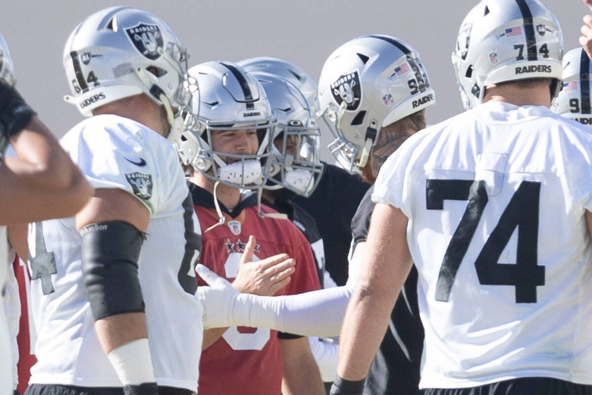 Raiders quarterback Jarrett Stidham (3), left center, shakes hands with defensive end Maxx Cros ...