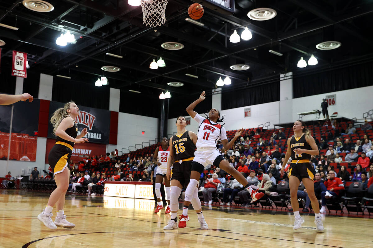 UNLV Lady Rebels guard Justice Ethridge (11) takes a shot under pressure from Wyoming Cowgirls ...