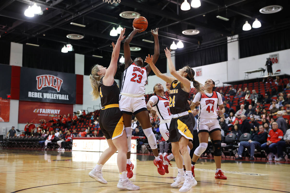 UNLV Lady Rebels center Desi-Rae Young (23) takes a shot under pressure from Wyoming Cowgirls f ...