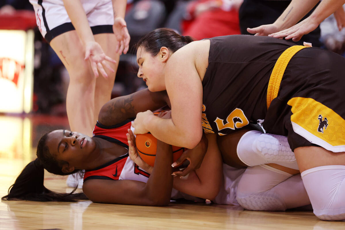 UNLV Lady Rebels center Desi-Rae Young (23) and Wyoming Cowgirls forward Marta Savic (15) fight ...
