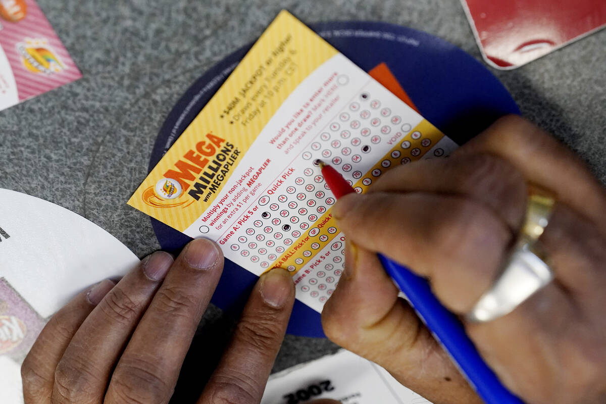 FILE - A customer fills out a Mega Millions lottery ticket at a convenience store in Northbrook ...