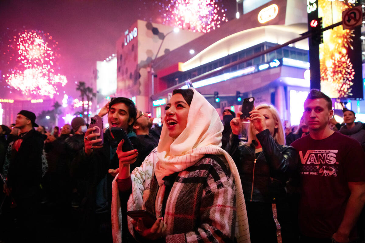 New Year’s Eve revelers watch the fireworks on the Strip on Saturday, Dec. 31, 2022, in Las V ...