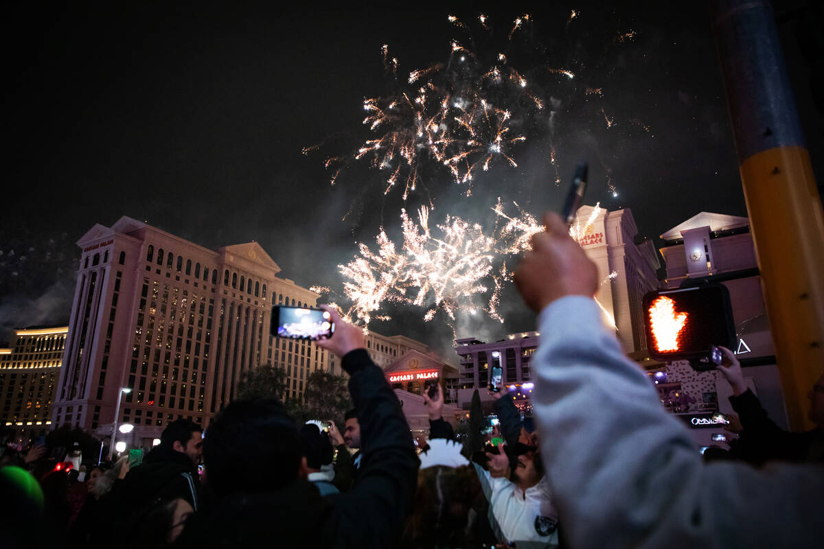 New Year’s Eve revelers take photos and watch the fireworks on the Strip on Saturday, Dec. 31 ...
