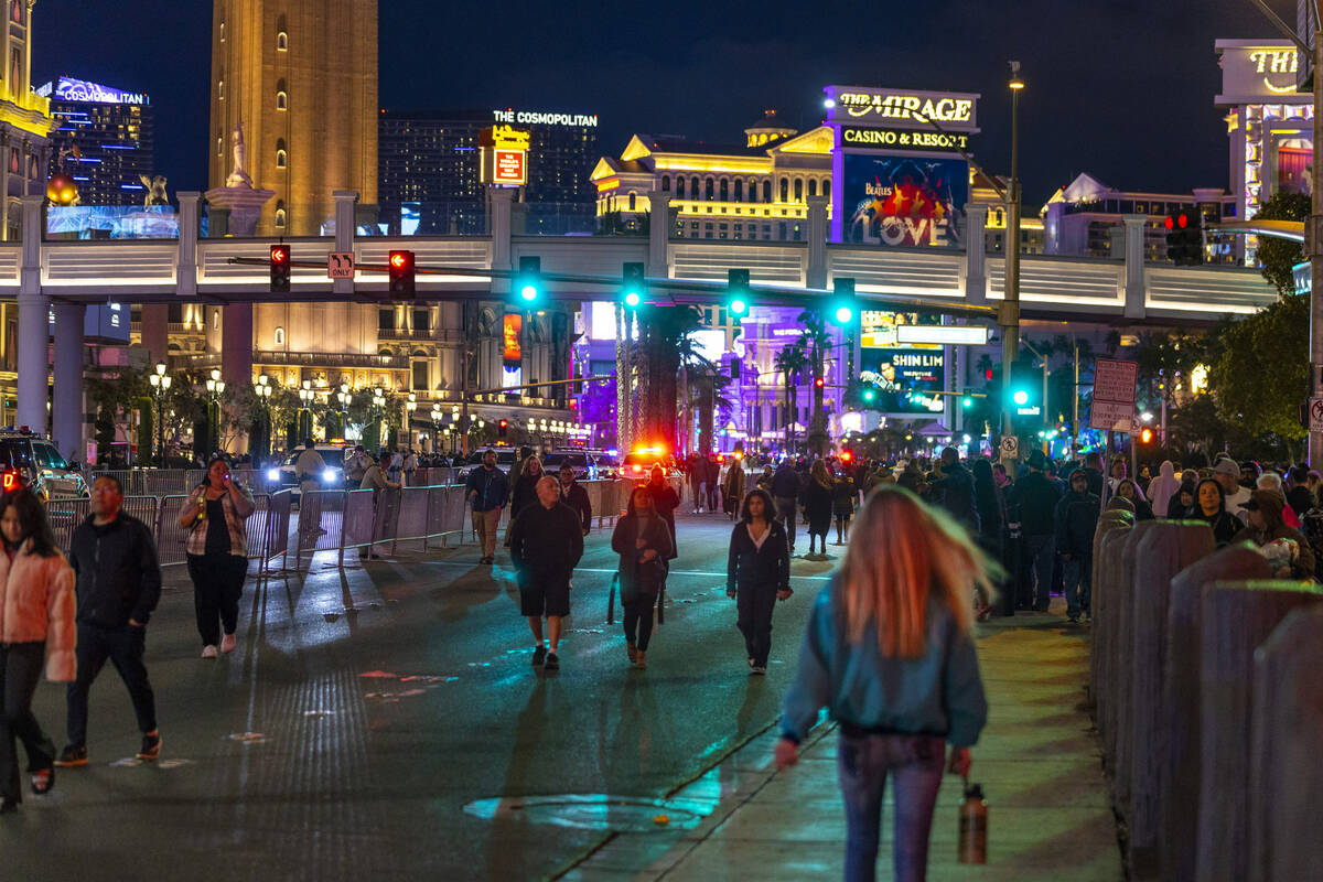 New Year’s Eve revelers move along the Strip on Saturday, Dec. 31, 2022, in Las Vegas. ( ...