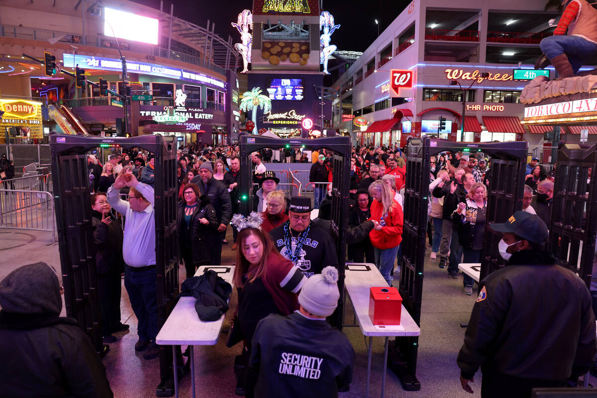 Revelers go through security on New Year’s Eve at the 4th Street entrance to the Fremont ...