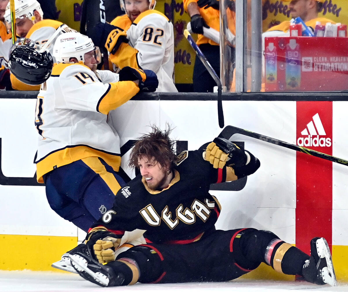Vegas Golden Knights right wing Jonas Rondbjerg, right, loses his helmet and stick after a chec ...