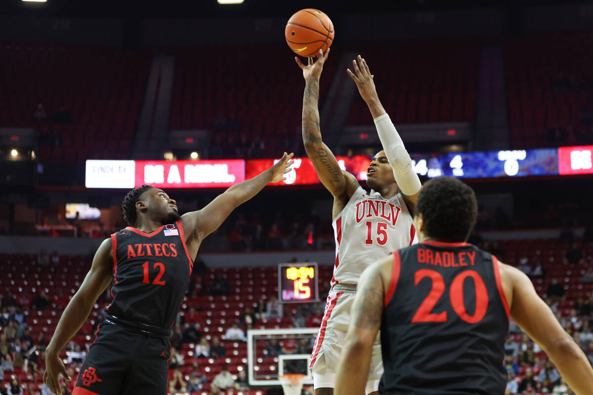 UNLV Rebels guard Luis Rodriguez (15) takes a shot under pressure from San Diego State Aztecs g ...