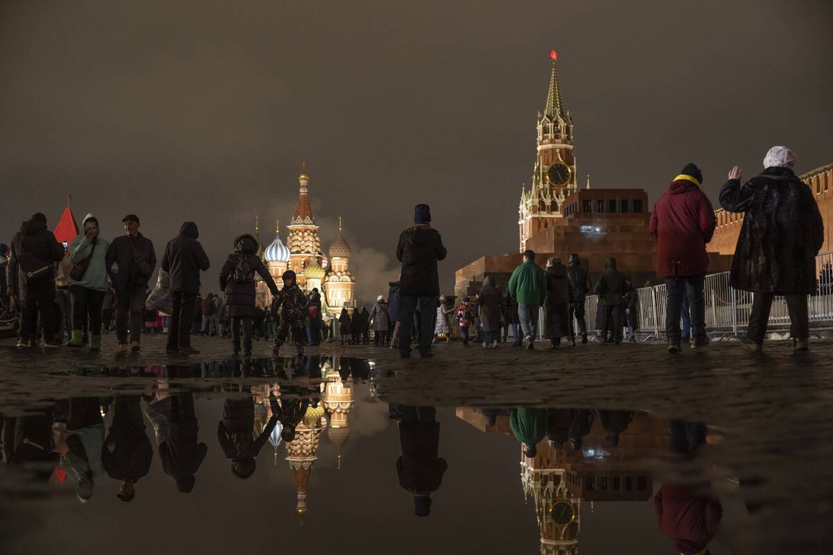 People walk in the Red Square prior to its closure for celebrations on the New Year's Eve, with ...