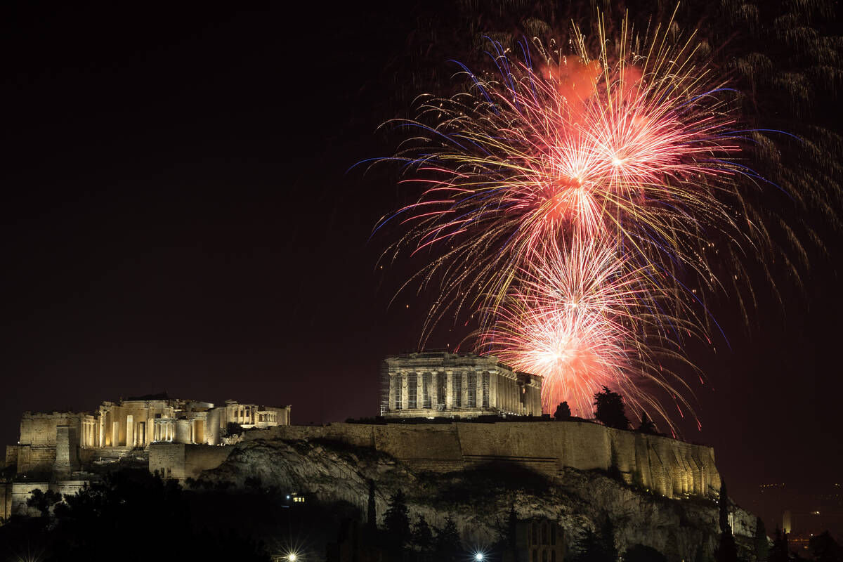 Fireworks explode over the ancient Parthenon temple at the Acropolis hill during New Year celeb ...