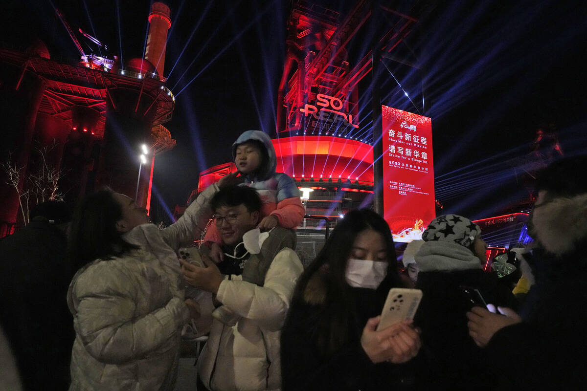 Revellers take photos after a count down to the new year at the Shougang Park in Beijing, Sunda ...