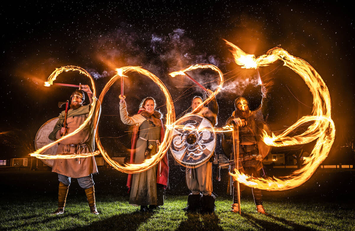 Viking reenactors use flaming torches to write 2023 at the Flamborough Fire Festival, a Viking ...