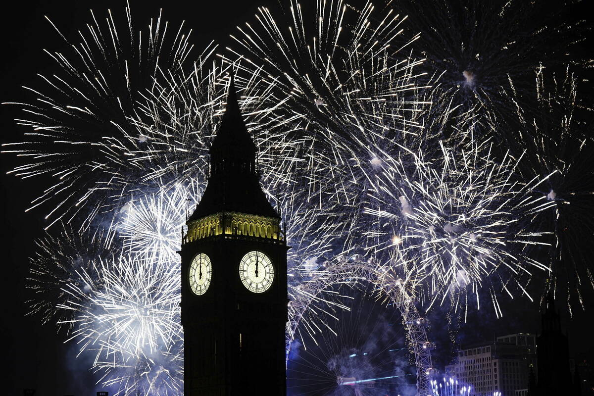 Fireworks illuminate the Elizabeth Tower, part of the Houses of Parliament, and the London Eye ...