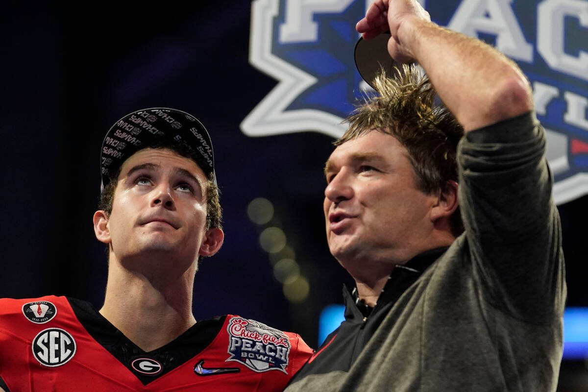 Georgia quarterback Stetson Bennett celebrates with Georgia head coach Kirby Smart after the Pe ...