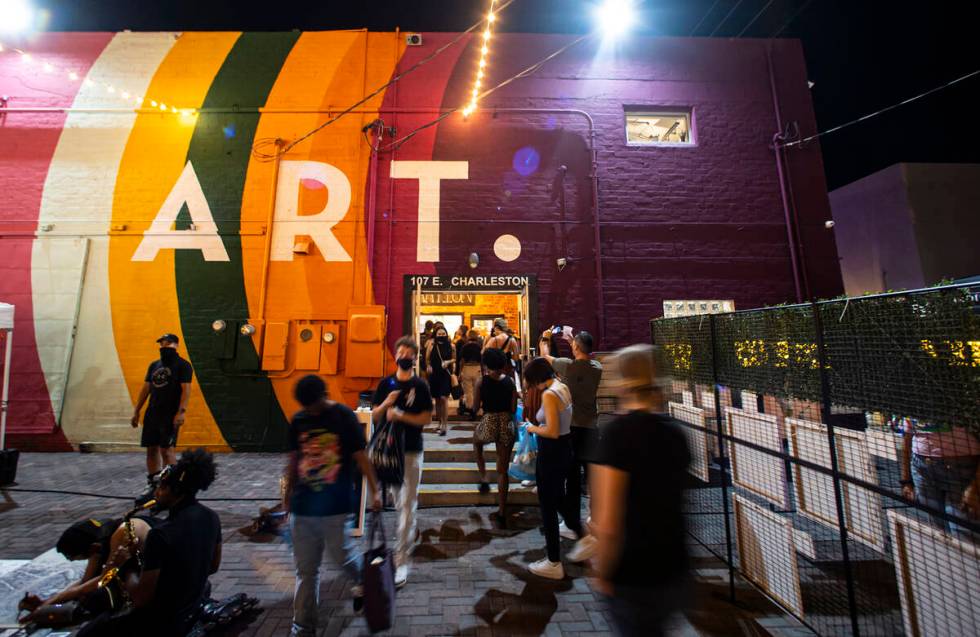 People walk around outside of the Arts Factory during First Friday in the Arts District of down ...