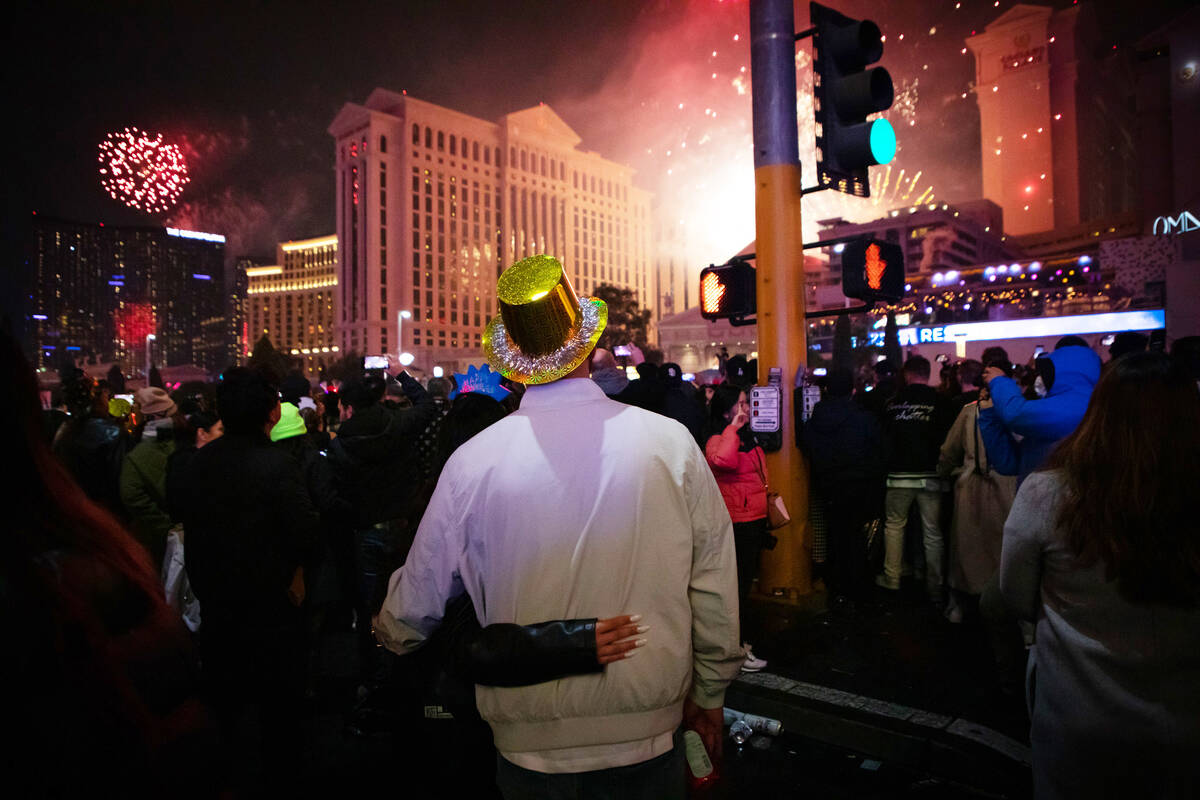 New Year’s Eve revelers watch the fireworks on the Strip on Saturday, Dec. 31, 2022. (Am ...