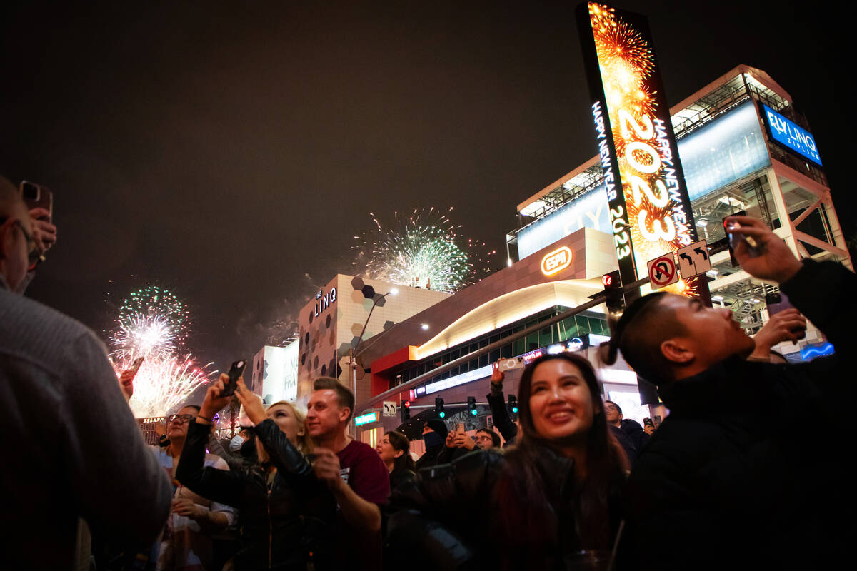 New Year’s Eve revelers watch the fireworks on the Strip on Saturday, Dec. 31, 2022. (Am ...