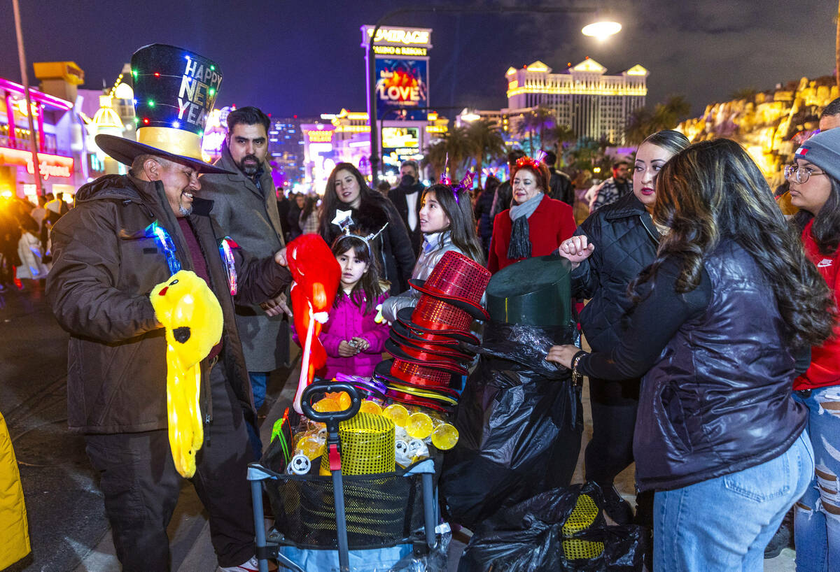 Ishmael Devora sells his holiday hats and other items near the Mirage on New Year’s Eve ...