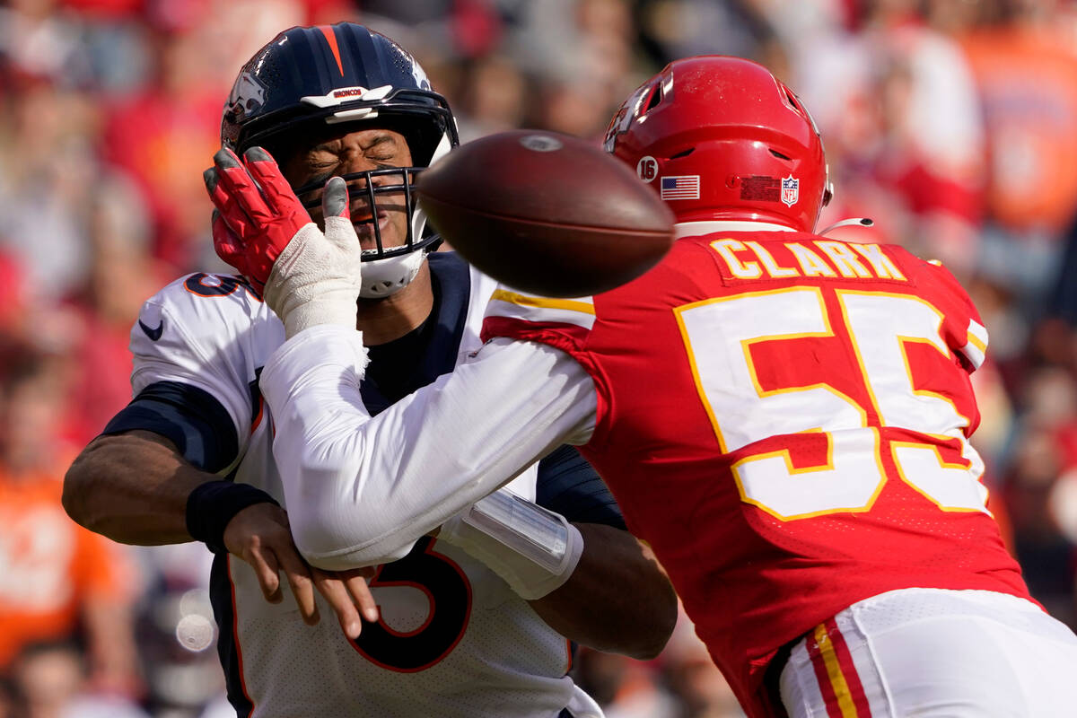 Denver Broncos quarterback Russell Wilson, left, is hit by Kansas City Chiefs defensive end Fra ...